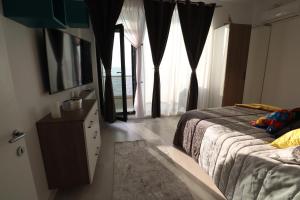 北马马亚-讷沃达里PANORAMIS PROMENADA-CEZAR的一间卧室配有一张床、梳妆台和窗户。