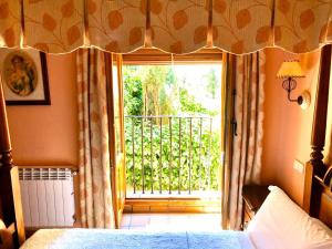 塞普尔韦达Hostal Posada La Panadera的一间卧室设有一张床和一个阳台的窗户。