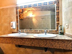 塞普尔韦达Hostal Posada La Panadera的一间带两个盥洗盆和大镜子的浴室