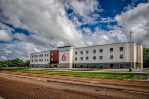 北普拉特Motel 6 North Platte - East的一座白色的大建筑,上面有红色的标志