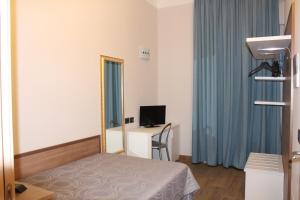 米兰豪斯比阿特丽斯米兰酒店的一间卧室配有一张床、镜子和一张书桌