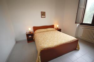 莱乌卡阿尔伯托德塞图里奥酒店的一间卧室配有一张床,桌子上放着两把蜡烛