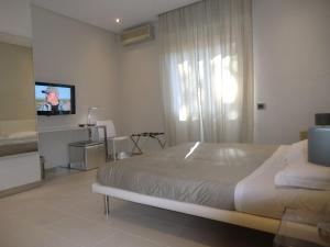 卡利亚里B&Beach Cagliari guest house的一间卧室配有一张床和一台平面电视