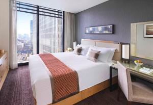 东京东京奥卓豪景酒店公寓的一间卧室配有一张大床、一张桌子和一个窗户。