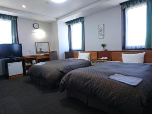 松山松山终端酒店的酒店客房设有两张床和一台平面电视。