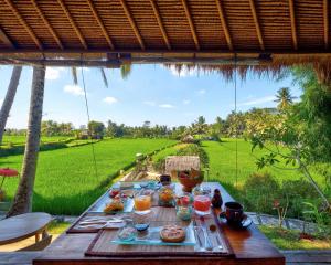 乌布MATHIS Retreat Ubud的一张桌子,上面放着食物,享有田野的景色