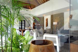 塞米亚克阿卡拉别墅酒店的客厅配有白色家具和植物