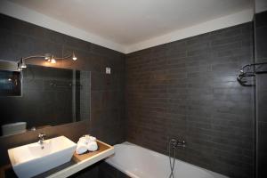 埃拉蒂扎戈里雅典娜酒店的浴室配有盥洗盆、浴缸和盥洗盆