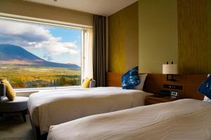 雫石町雫石王子酒店的酒店客房设有两张床和大窗户。