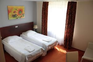 华沙Hotel Gordon的酒店客房设有两张床和窗户。