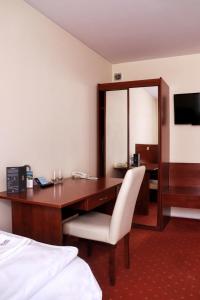 华沙Hotel Gordon的酒店客房配有一张桌子、一把椅子和一张床