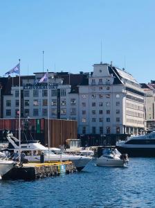 卑尔根Magic Hotel & Apartments Kløverhuset的一群船停靠在港口,有建筑物