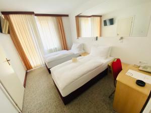 温科夫齐Hotel Slavonija的酒店客房配有两张床和一张书桌