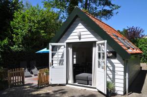 斯霍尔Rob's Cottage的绿色屋顶的白色小棚子