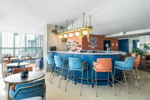 赖阿南纳千年公寓的餐厅设有蓝色酒吧,配有桌椅