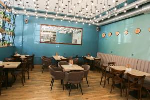 圣彼得堡Prestige Center的一间配备有桌椅的用餐室和蓝色的墙壁