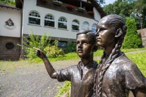 奥登塔尔Märchenwald Altenberg B&B Hotel的一座建筑物前方有两名儿童的雕像