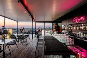 赖阿南纳千年公寓的一间酒吧,位于一座建筑物的屋顶上,人们坐在桌子上
