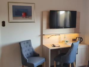 博尔库姆鲁塞旅馆的一间带两把椅子、一张桌子和一台电视的房间