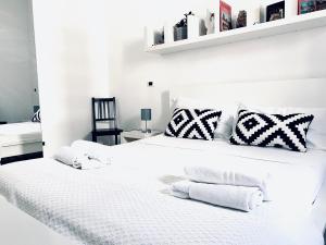 帕基诺U Palazzieddu Rooms的卧室配有白色的床和黑白色枕头