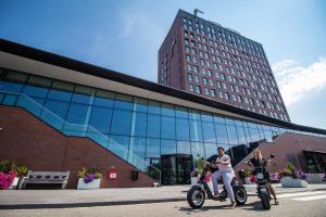 霍恩霍伦范德沃尔酒店 的两人骑摩托车在大楼前