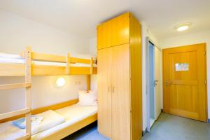 文西德尔Jugendherberge Wunsiedel的宿舍间设有双层床和衣柜。