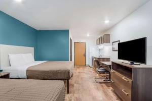 查尔斯顿WoodSpring Suites | North Charleston Airport I-526的酒店客房设有两张床和一台平面电视。
