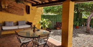 坎德莱达casa Rural Las Traviesas的庭院配有玻璃桌、椅子和沙发