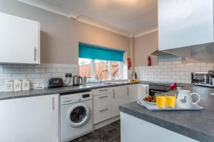 米德尔斯伯勒James Cook Accommodation的厨房配有水槽和洗衣机