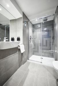 约克Roomzzz York City的带淋浴、浴缸和盥洗盆的浴室