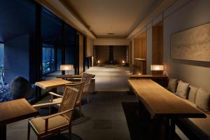 札幌ONSEN RYOKAN Yuen Sapporo的一间带木桌和椅子的餐厅以及走廊