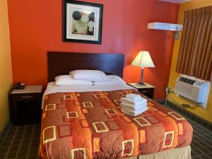 Wrightstown莱茨敦苏格兰汽车旅馆的一间卧室配有一张带橙色墙壁的大床