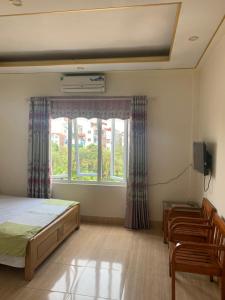 河内Nhà nghỉ Diễm Quỳnh Nội Bài的一间卧室配有一张床、一个窗口和椅子