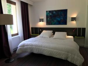 旺特龙La maison de Cécile的卧室配有一张带两个枕头的大白色床
