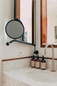 巴黎Hôtel Wallace - Orso Hotels的浴室水槽配有镜子和2瓶肥皂