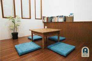 花莲市House 303 小阿姨的家民宿的一张带蓝色靠垫的木桌