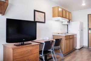 阿马里洛WoodSpring Suites Amarillo East I-40的厨房配有带2把椅子的梳妆台,配有电视