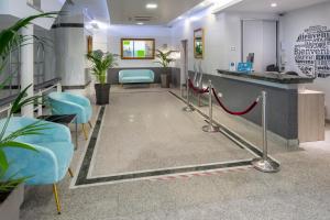 萨洛4R Casablanca Playa的一间设有蓝色椅子和红地毯的等候室