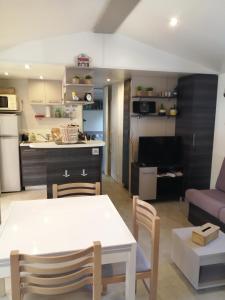 维亚斯Mobil home La Mer的厨房以及带白色桌椅的起居室。