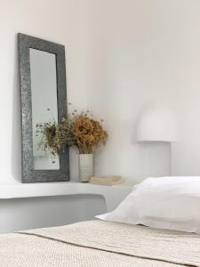 维琪奥港Résidence Les Toits de Santa Giulia的一张镜子,墙上是白色的,床边是镜子