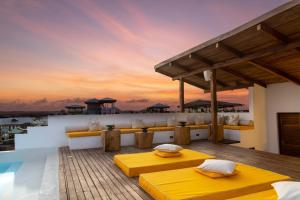 桑给巴尔Upendo House Hotel Zanzibar的别墅的甲板上设有两张床。