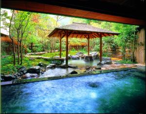 丰冈市西村屋招月庭的一个带凉亭和溪流的水池