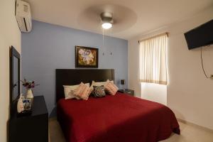 科利马El Rincon de Los Angeles的一间卧室配有红色的床和红色毯子