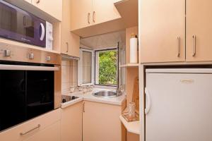 杜布罗夫尼克Apartman Dubrovnik的厨房配有白色冰箱和水槽