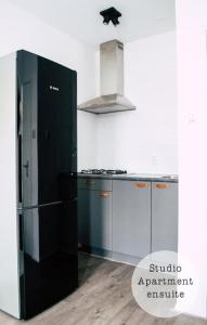 阿姆斯特丹伦勃朗广场酒店的厨房配有黑色冰箱和炉灶。