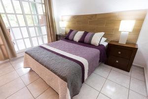 坎昆Quetzal Loft的一间卧室配有一张带木制床头板的床