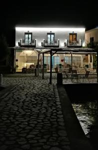 卡利诺岛Afrodite Luxury Rooms的一座在晚上点燃的建筑,设有石头庭院