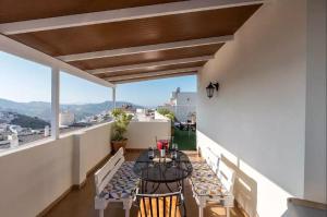 阿洛拉Ático Guadalhorce - Mirador privado con barbacoa y solárium的阳台的天井配有桌椅