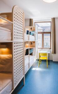 布达佩斯NETIZEN Budapest Centre的客房设有双层床、桌子和黄色凳子