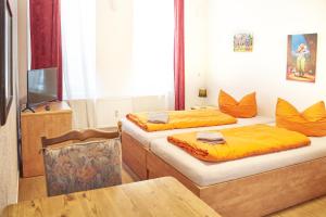 莱比锡衮尼莫佩拉旅馆的客房设有两张床、一张桌子和一台电视机。